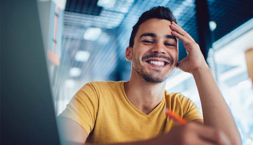 Imagem Rapaz sorridente no ambiente de trabalho.