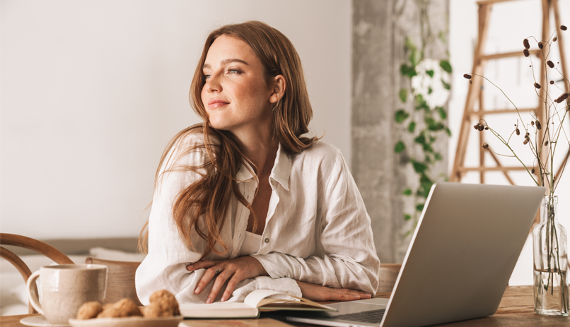 Imagem Mulher sentada a mesa com o computador