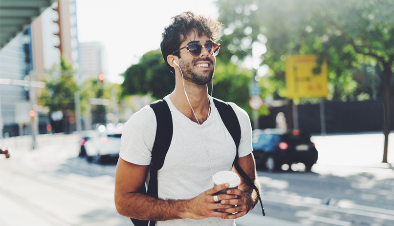 Jovem com mochila nas costas, sorrindo e trazendo confiança no olhar.