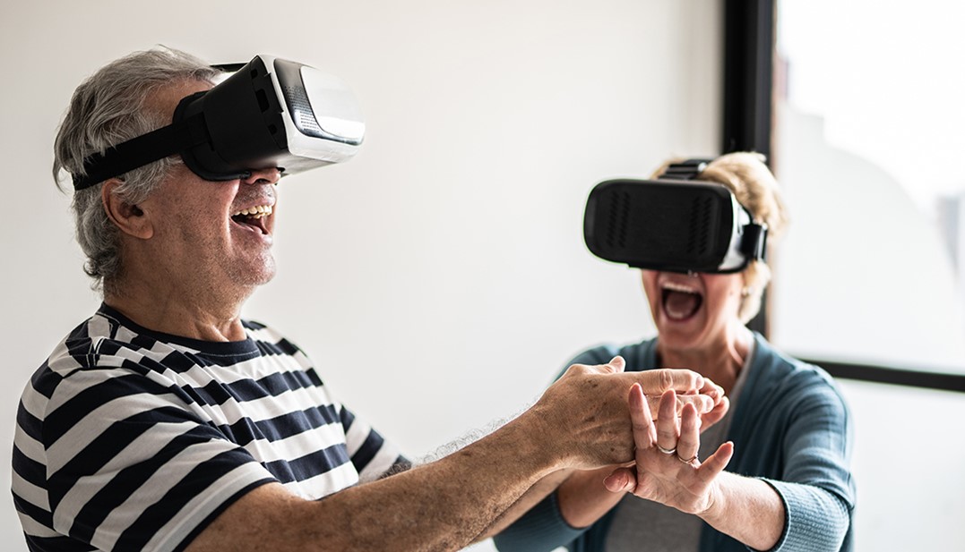 Dois idosos com óculos de realiadade virtual sorrindo