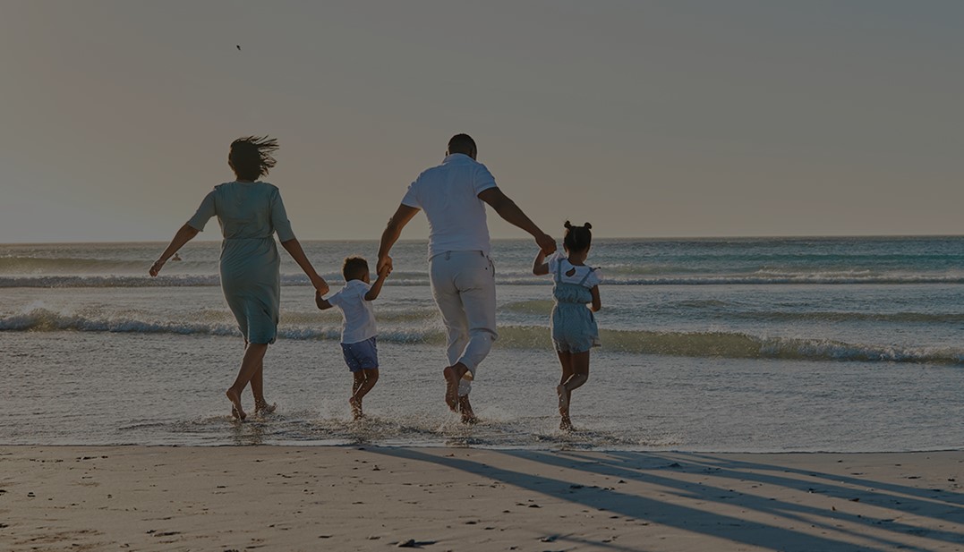 Família correndo em direção ao mar