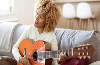 Mulher negra tocando violão